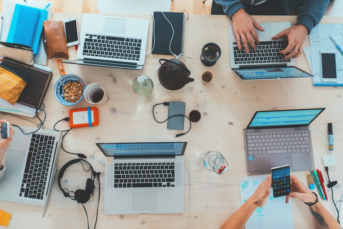 Các thành viên cùng làm việc với laptop và tài liệu trên bàn